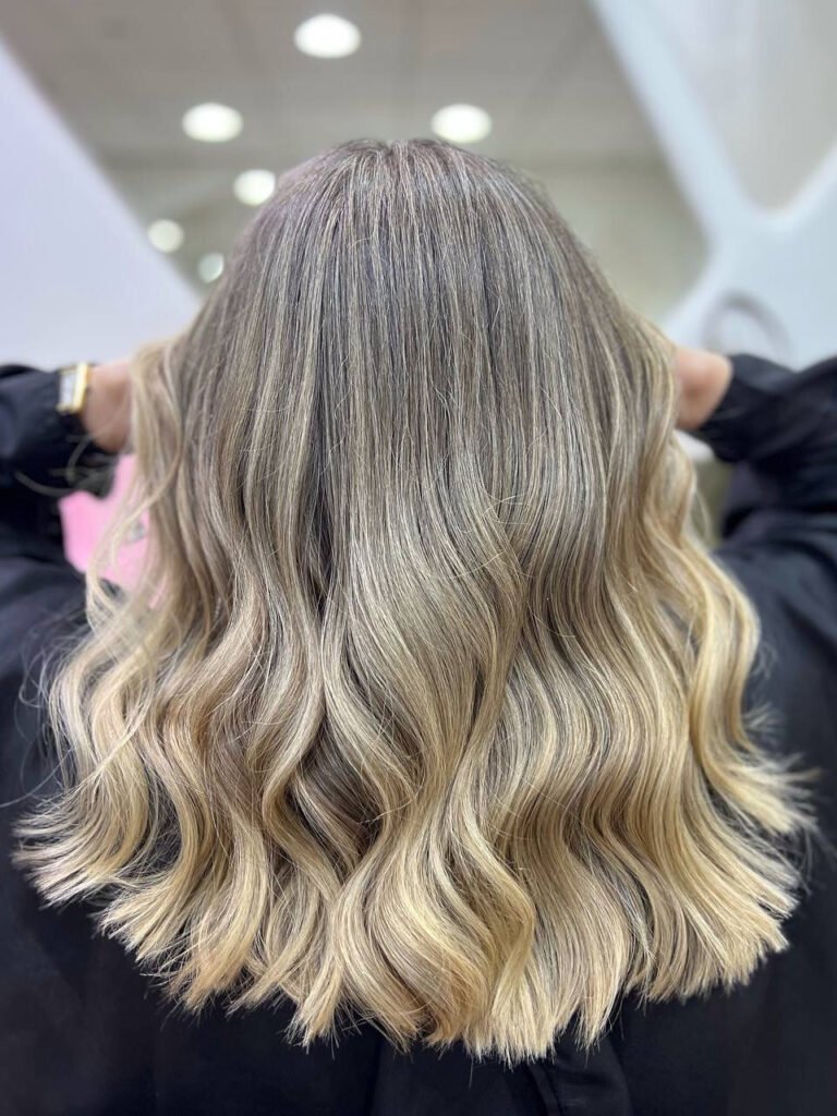 Shoulder-length blonde balayage with soft waves styled at Beauty Hunters in The Pearl, Doha