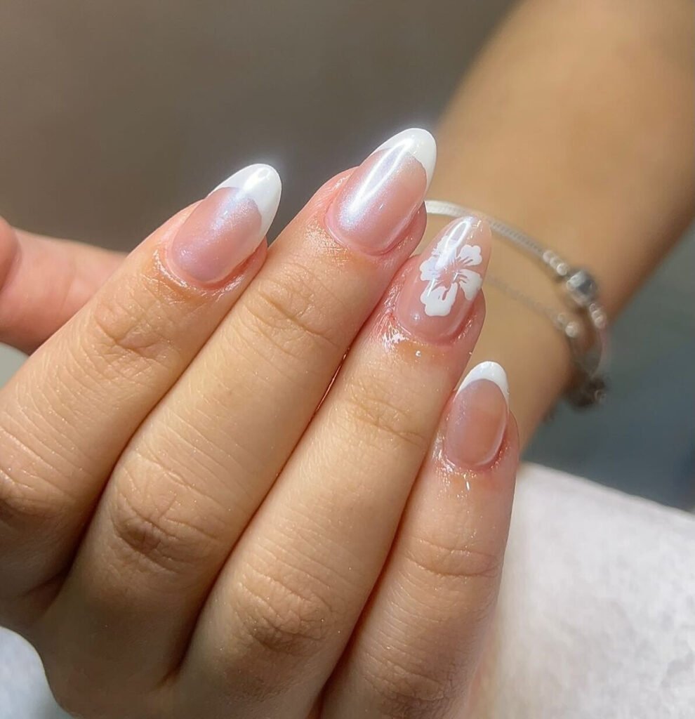Almond french gel manicure with a white flower accent nail at Kensington Hair & Beauty in Doha