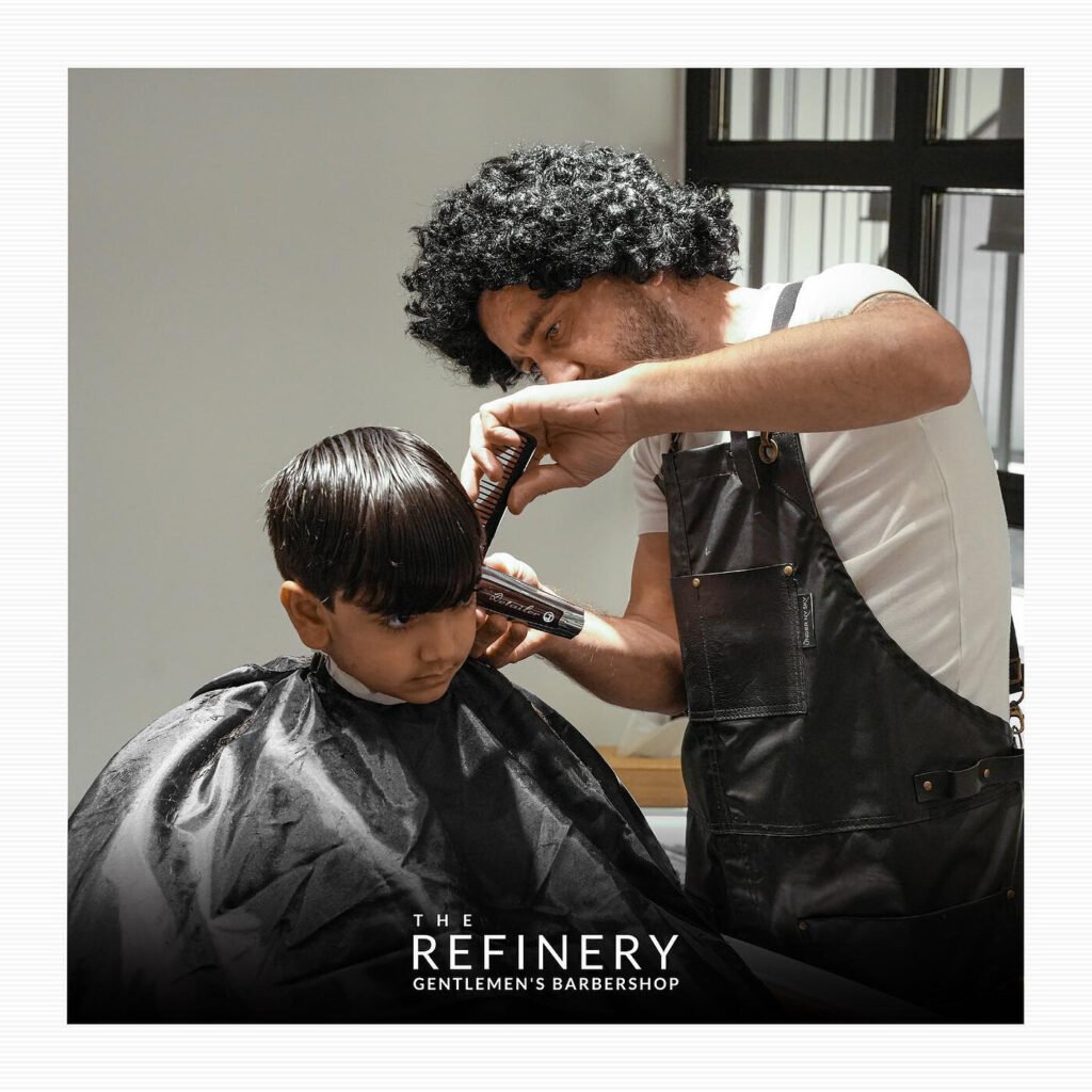 Child having a haircut at The Refinery Gentlemen's Barbershop on The Pearl, Doha